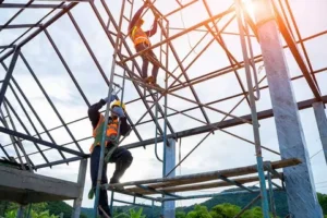 Construction workers on scaffolding assembling a steel structure.