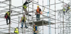 Construction workers assembling scaffolding structure with safety gear