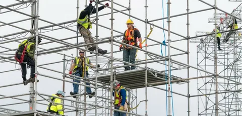 Workers installing scaffolding on a construction site in NYC